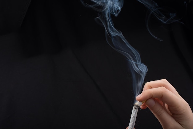 close-up of hand holding cigarette
