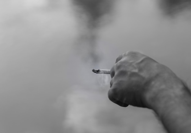 Photo close-up of hand holding cigarette