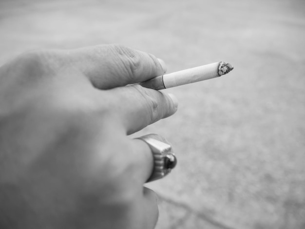 Photo close-up of hand holding cigarette