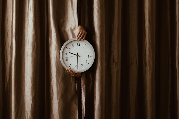 Foto close-up di un orologio a mano su una tenda