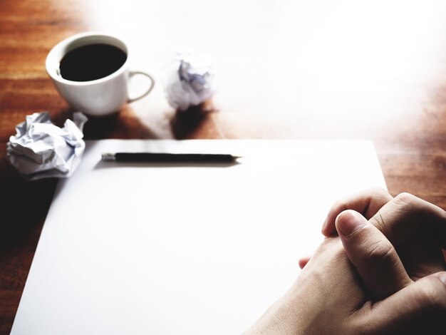 Photo close-up of hand holding coffee cup on table