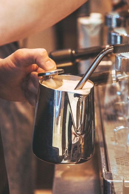 Foto close-up di una mano che tiene una tazza di caffè