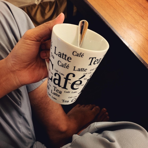 Photo close-up of hand holding coffee cup