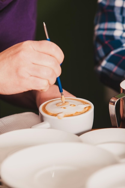 Foto close-up di una mano che tiene una tazza di caffè