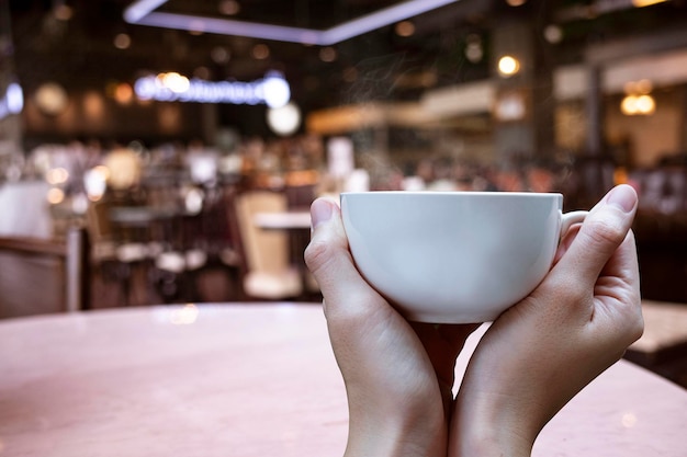 Photo close-up of hand holding coffee cup