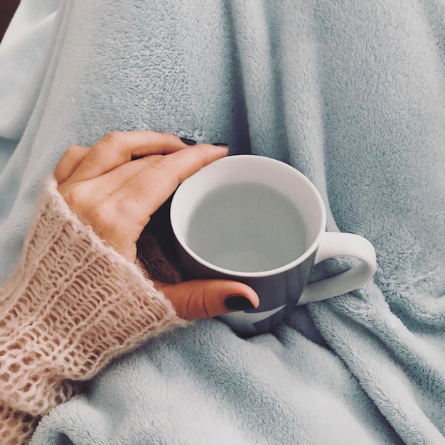 Close-up of hand holding coffee cup