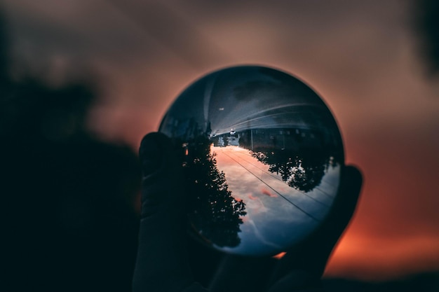 Photo close-up of hand holding crystal ball against blurred background