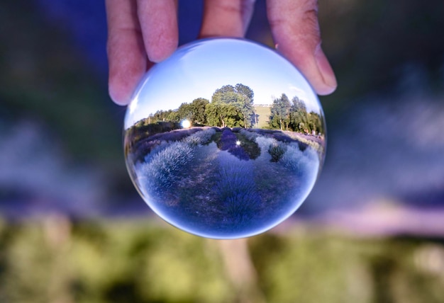 Foto close-up di una mano che tiene una palla di cristallo