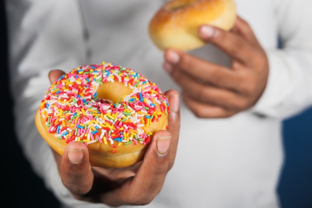 Photo close up of hand holding donuts .