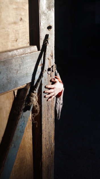 close-up of hand holding door against black background