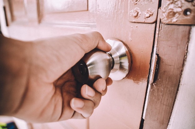 Photo close-up of hand holding door knob