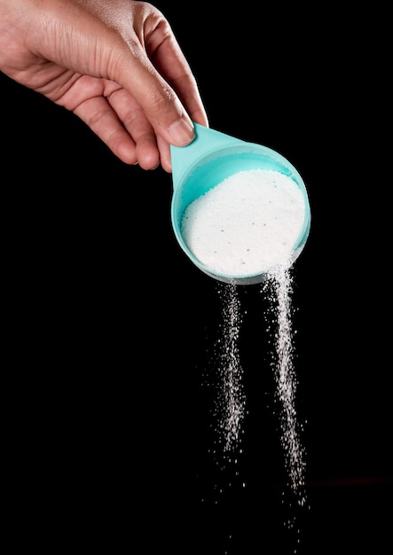 Photo close-up of hand holding drink over black background