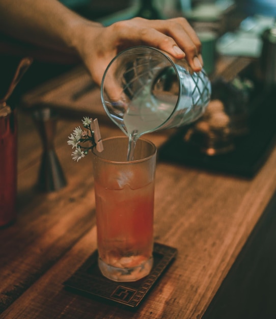 Close-up of hand holding drink served on table