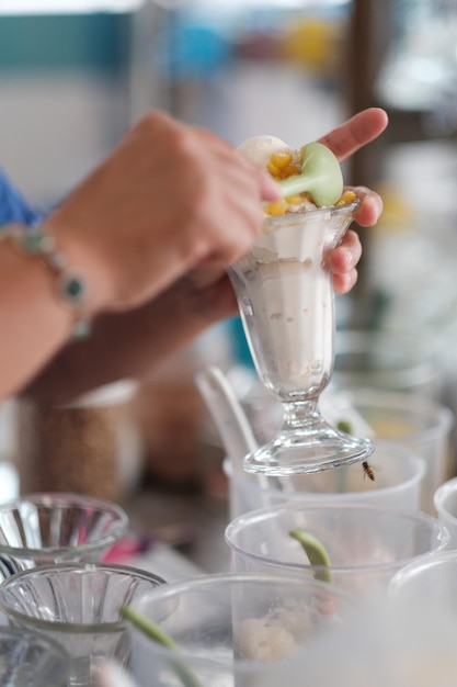 Close-up of hand holding drink on table