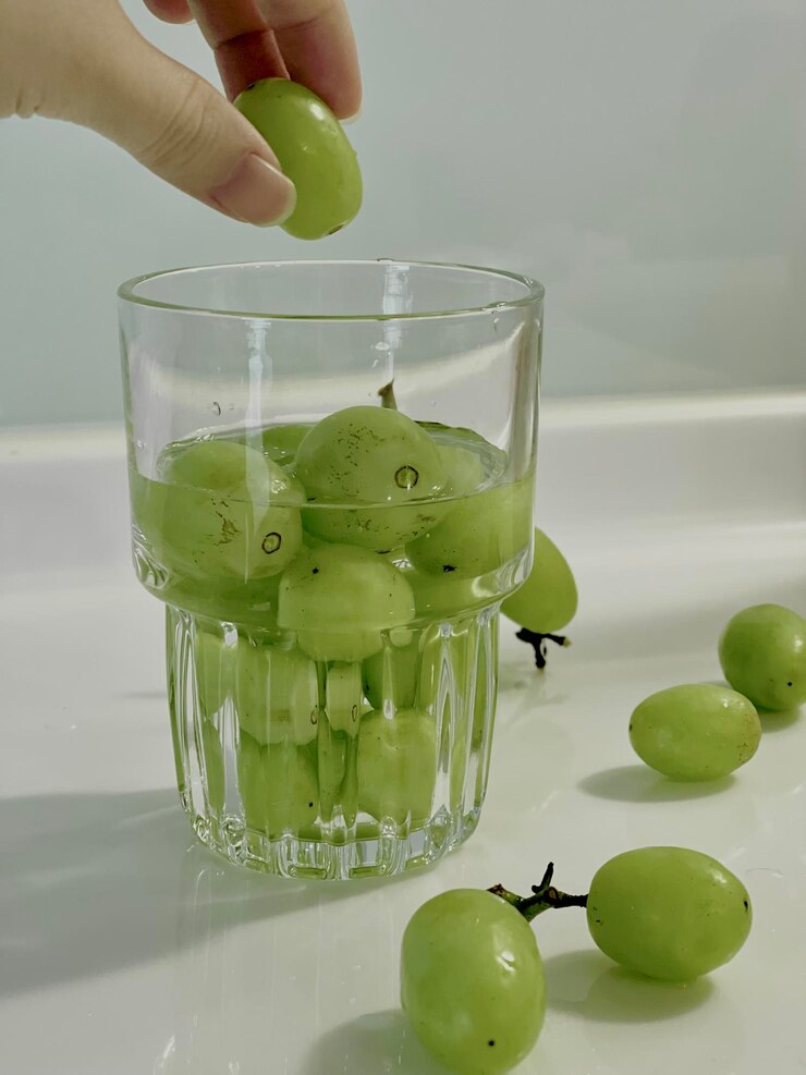 Photo テーブルの上で飲み物を握っている手のクローズアップ