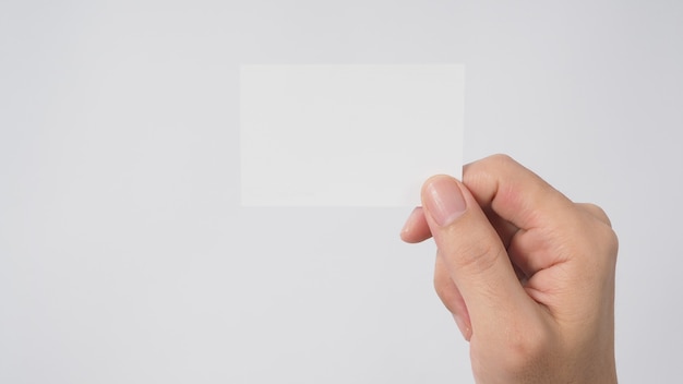 Close up of hand holding empty small card on white background.