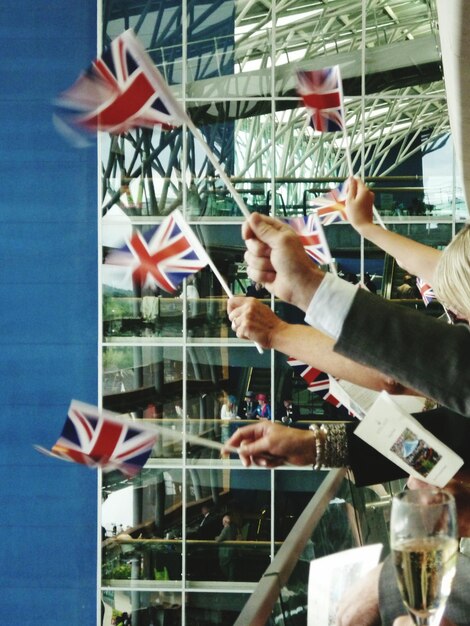 Photo close-up of hand holding flag in city