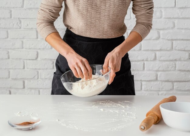 Photo close up hand holding flour bowl