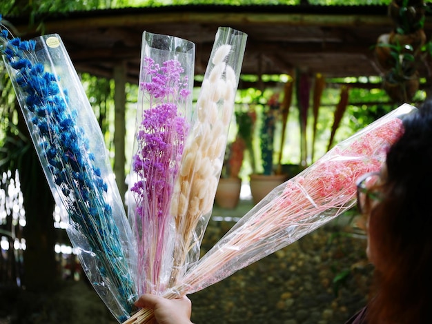 Close-up of hand holding flower in plastic