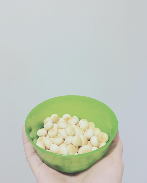 白い背景で食べ物を握っている手のクローズアップ