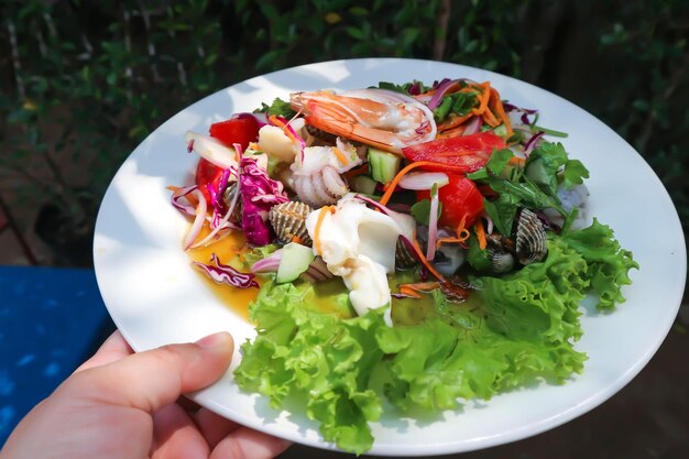 Close-up of hand holding food in plate