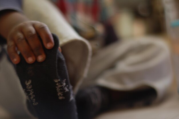 Photo close-up of hand holding foot