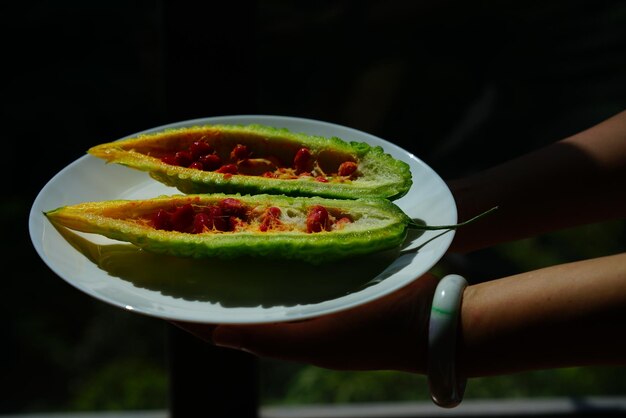 Foto close-up di una mano che tiene la frutta in un piatto