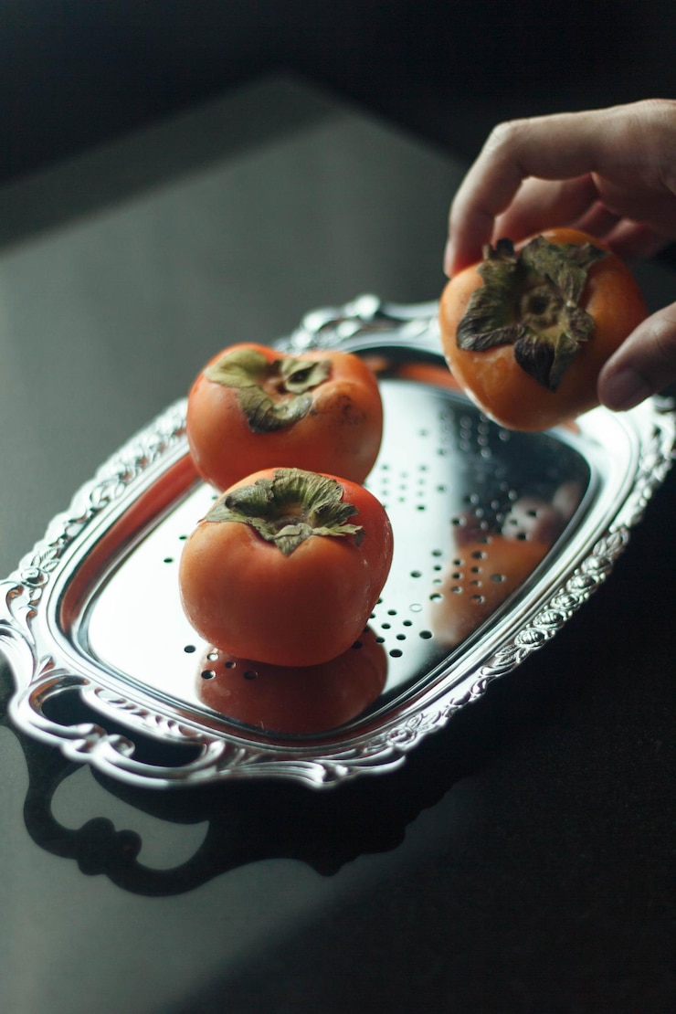 Photo close-up of hand holding fruit salad in plate