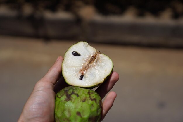 Foto close-up di una mano che tiene la frutta