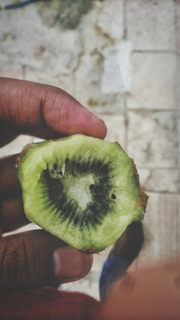 Foto close-up di una mano che tiene la frutta