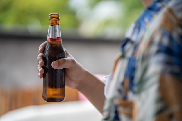 Close-up of hand holding glass of beer