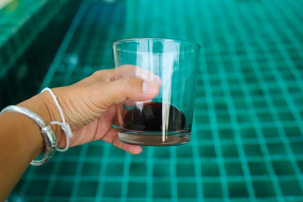 Close-up of hand holding glass of water