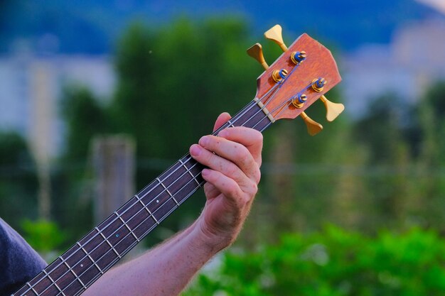 Photo close-up of hand holding guitar