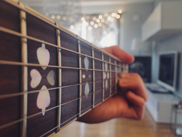 Photo close-up of hand holding guitar