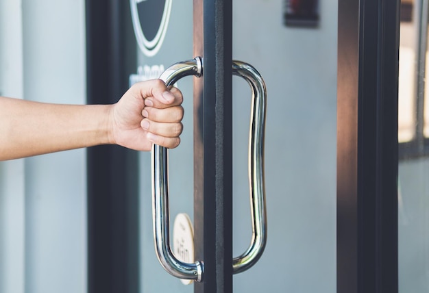 Photo close-up of hand holding handle of door