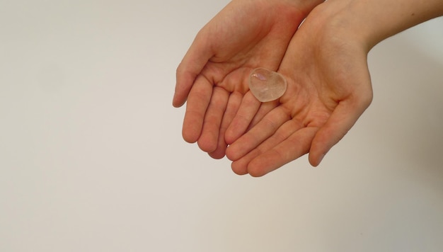 close-up of hand holding heart shape against white table