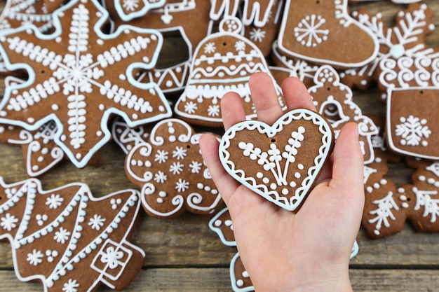 Photo close-up of hand holding heart shape cookies