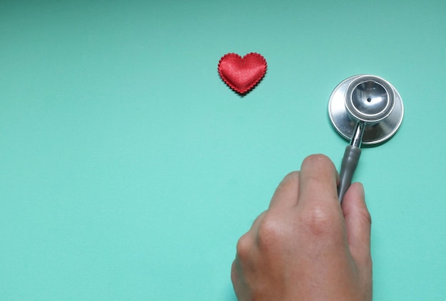 Close-up of hand holding heart shape over white background