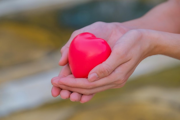 Photo close-up of hand holding heart shaped balloons