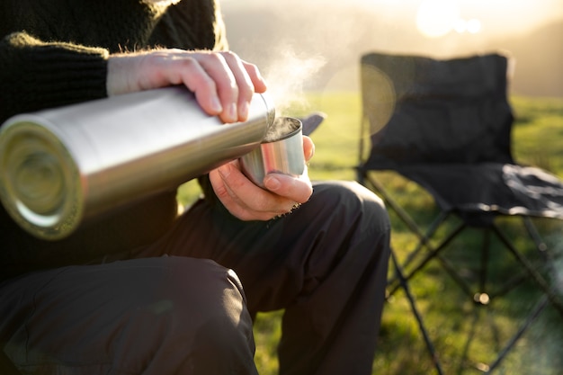 Photo close up hand holding hot water flask