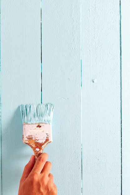 Close-up of hand holding ice cream against wall