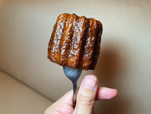 Close-up of hand holding ice cream against wall