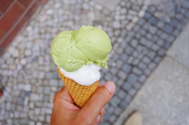 Photo close-up of hand holding ice cream cone