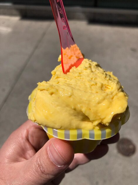 Foto close-up di un cono di gelato in mano