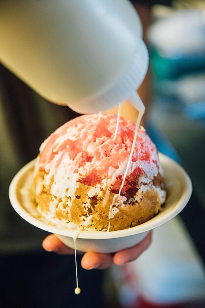 Foto close-up di un cono di gelato in mano