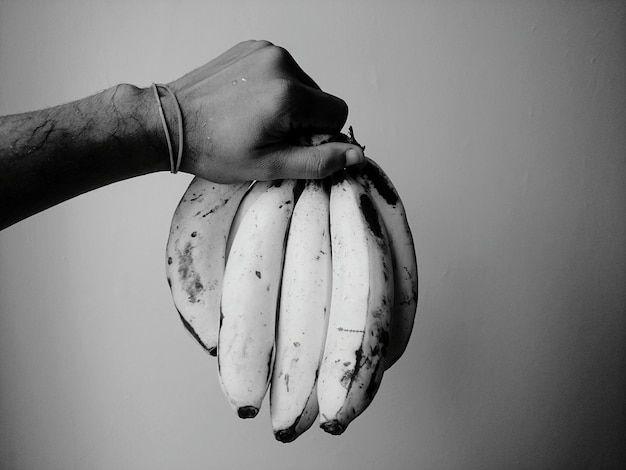 Photo close-up of hand holding ice cream over white background