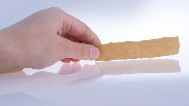 Foto close-up di una mano che tiene il gelato su uno sfondo bianco