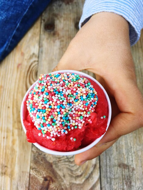 Photo close-up of hand holding ice cream