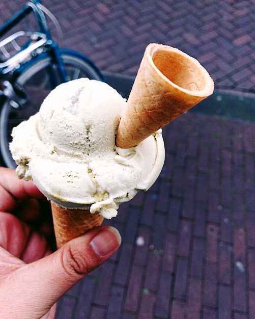 Photo close-up of hand holding ice cream