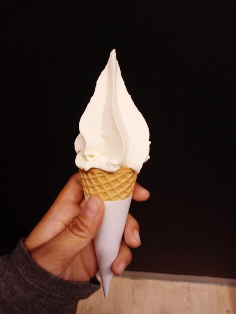 Photo close-up of hand holding ice cream